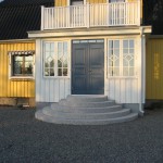 stentrappa framför gult hus